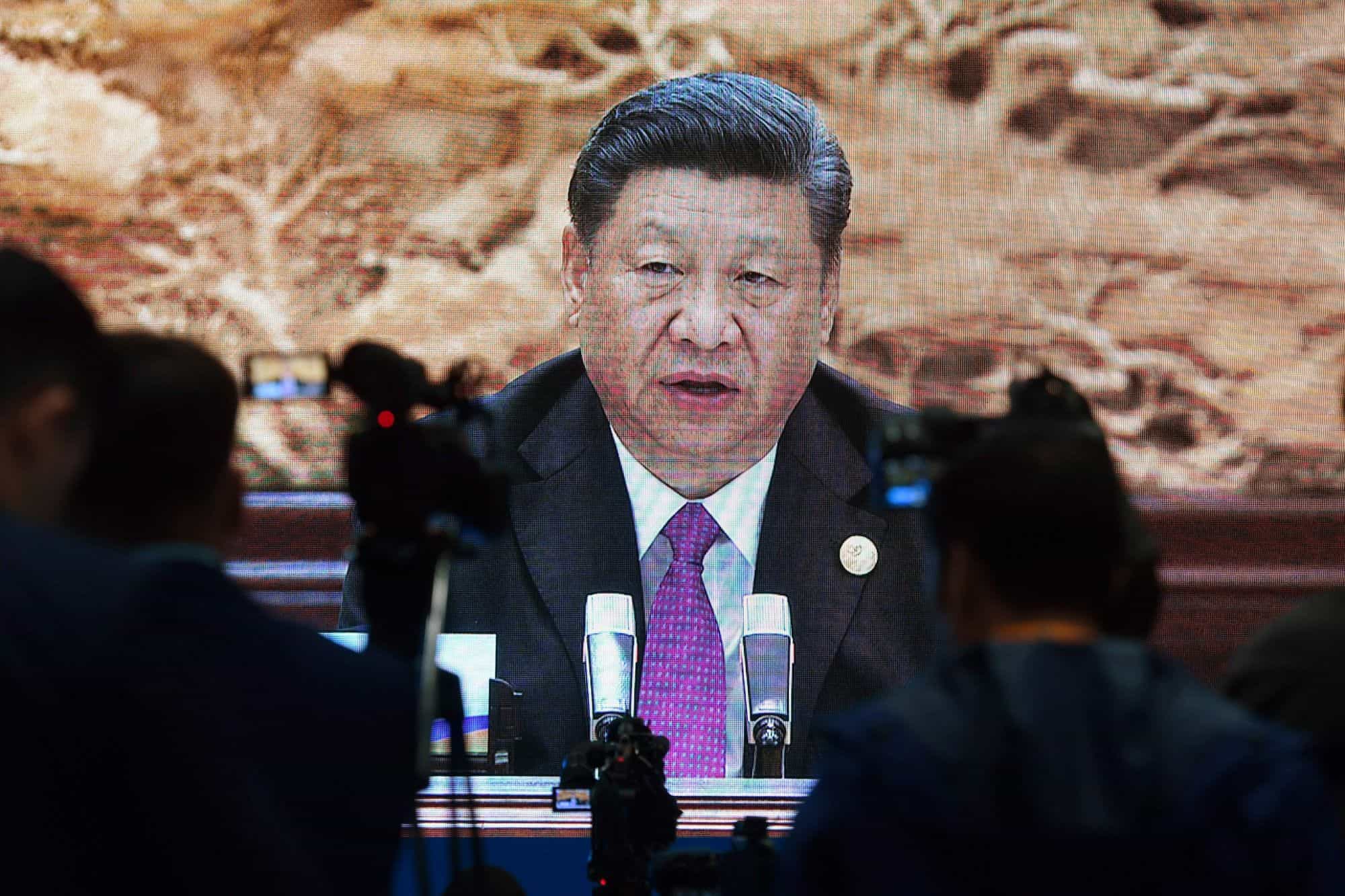 Journalists watch an image of Chinese President Xi Jinping speaking at the Belt and Road Forum in Beijing in April 2019.