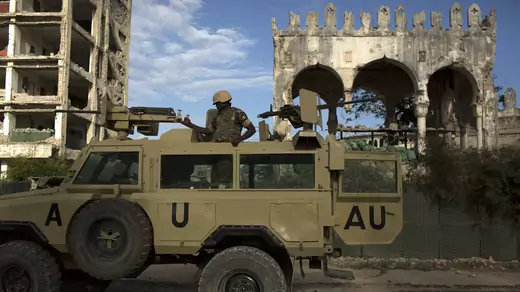 An AMISOM soldier keeps guard on top of an armored vehicle in Mogadishu.